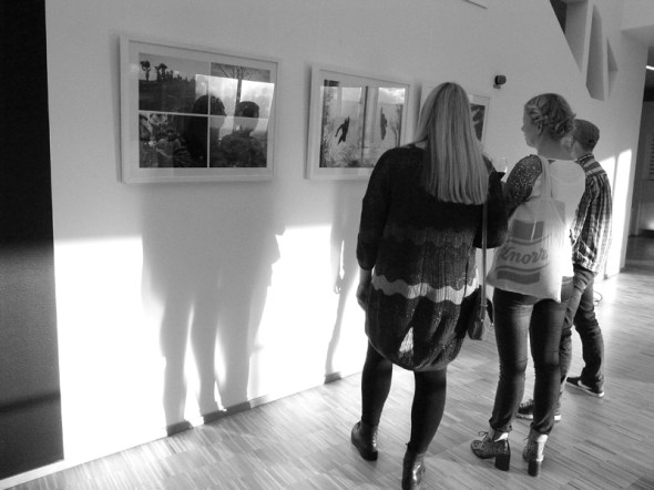 Besökare på utställningen kollar fotografierna