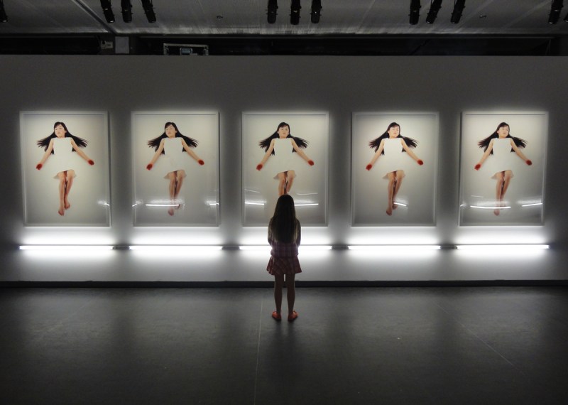 En liten besökare tittar på bilder av Motohiko Odani på Fotografiska museet 2013